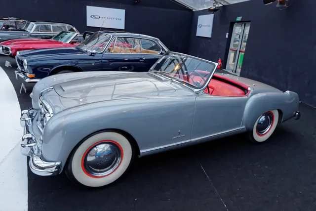 Opposite front three-quarter view retained for body contour, grille, wheel-cover, windshield, and cockpit inspection context.