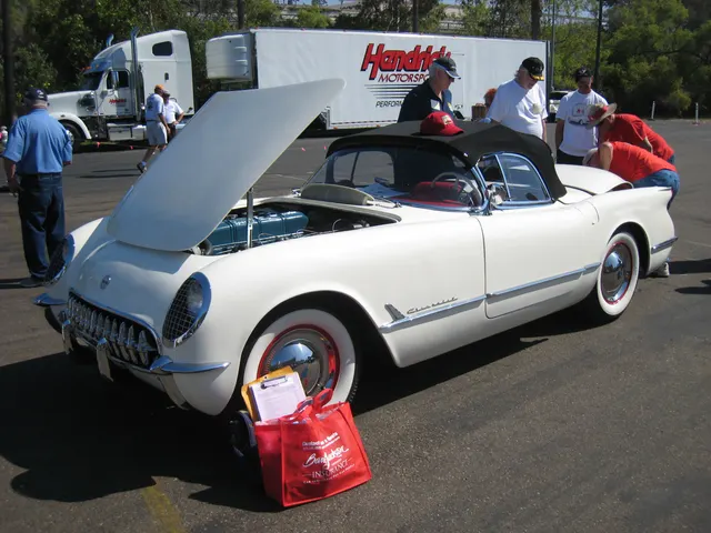 Restored 1953 Corvette with black top and side curtain installed, showing the first-year weather equipment, wheels, and open engine bay.