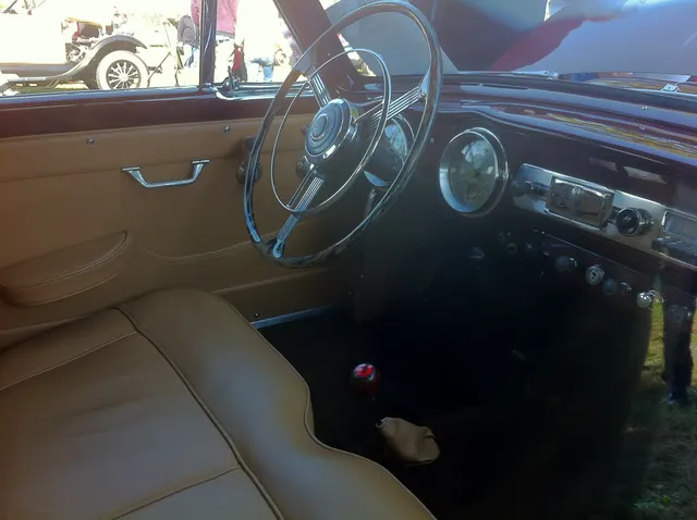 Driver-cockpit view of the 1953 Le Mans hardtop retained for dashboard, controls, upholstery, glazing, and body-specific interior context.