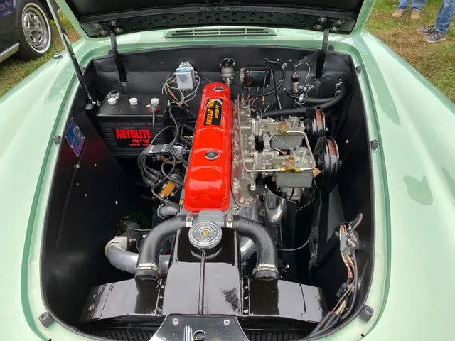Engine-bay view of an exact-year convertible showing the restored LeMans Dual Jetfire inline-six and twin Carter side-draft carburetors; finishes and service parts remain car-specific.