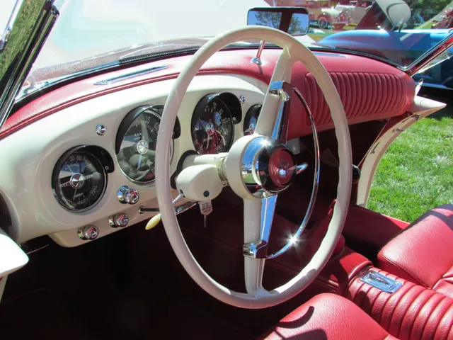 Driver's view of the Darrin instrument cluster, tachometer, steering wheel, controls, padded dash, upholstery, and floor shifter.