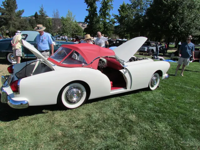 Rear-side view with the Deauville top raised and separate rear deck lids open, documenting the top well, trunk access, pocket-door opening, and roadster body.
