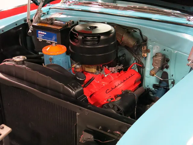 Restored 1955 Bel Air engine compartment with a 265-cid V8 and two-barrel-style oil-bath air cleaner; finishes and service parts remain specific to this museum car.