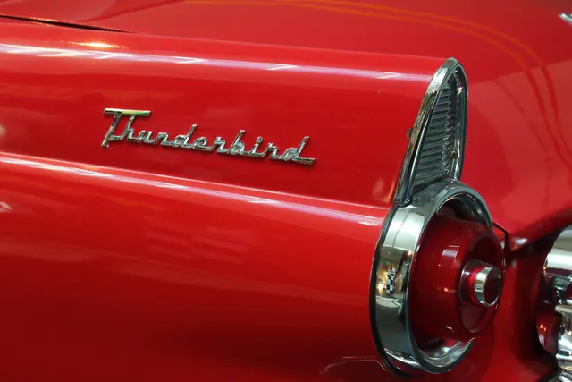 Rear three-quarter view of the same museum car showing the short deck, rear fender skirts, script, lamps, bumper, and dual exhaust outlets through the bumper guards.