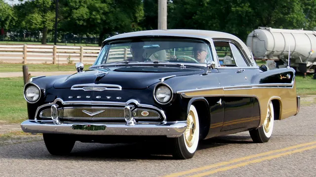Second exact-model front view showing the grille, headlamps, bumper, hood treatment, windshield, hardtop opening, side sweep, and wheel-cover treatment.