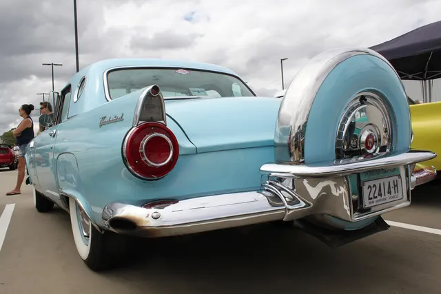 Low rear detail showing the spare carrier, bumper, lamps, deck, and body relationship.