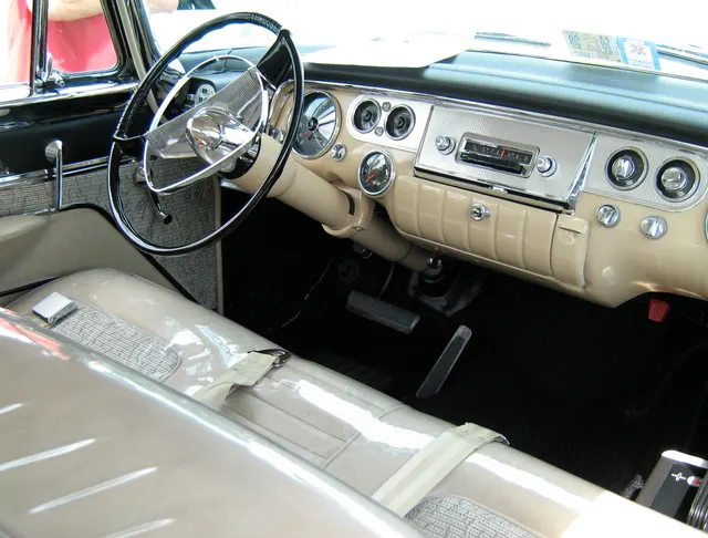Exact-year Fury cabin showing the dashboard, steering wheel, instruments, controls, front bench, and door trim; clear seat covers and restoration details remain car-specific.