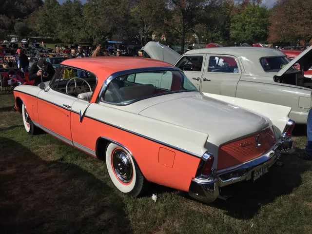 Rear three-quarter view showing the pillarless roof, fiberglass fins, check-mark side trim, and two-tone paint break