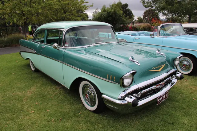 Two-door post sedan showing its fixed B-pillar, roof, door glass, body-side trim, wheels, and family proportions.
