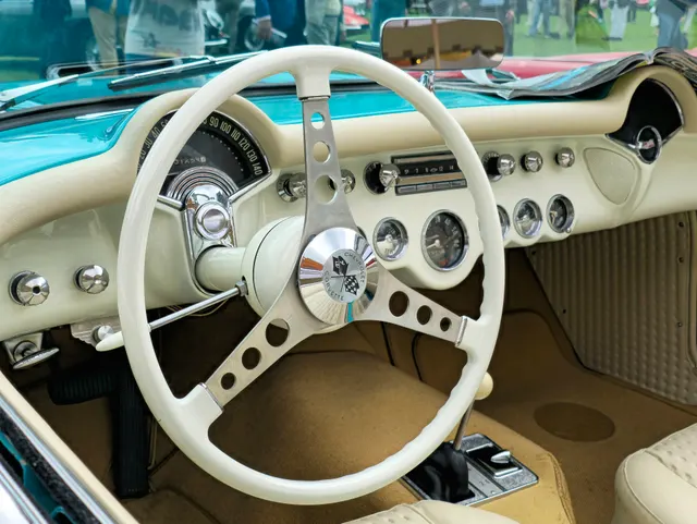 1957 Corvette Fuelie cockpit detail showing upholstery, dashboard, steering wheel, gauges, and controls.
