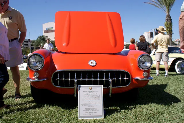 Head-on view of a restored-stock 1957 Corvette showing the single-headlamp front, grille, bumper, and parking lamps.