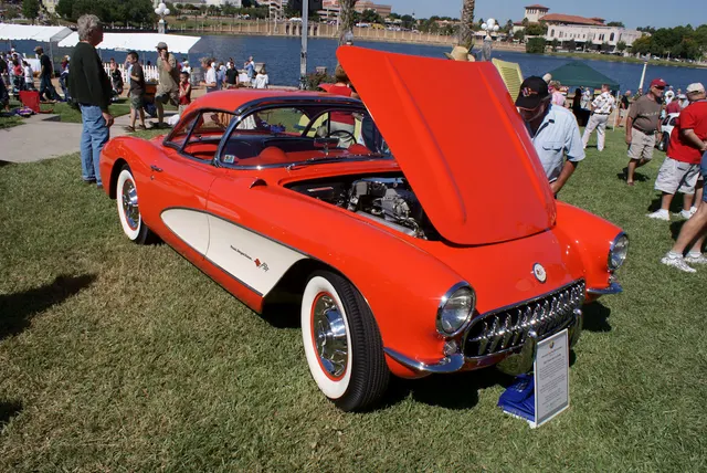 Right-front view of a restored-stock 1957 Corvette showing the body-side cove, wheel treatment, windshield, and front details.