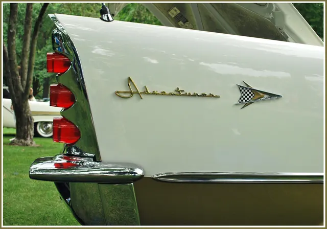 Exact-model rear-fender detail showing the fin, three-lens taillight tower, gold Adventurer script, checkered-flag badge, and bumper exhaust outlet.