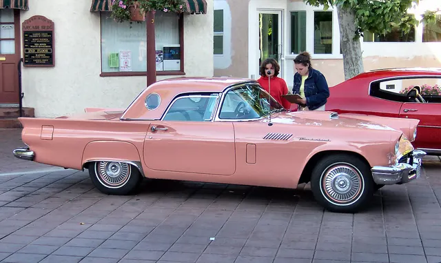 Hardtop side profile showing the two-seat proportions, porthole roof, finned quarters, and vertically stored spare's trunk area.