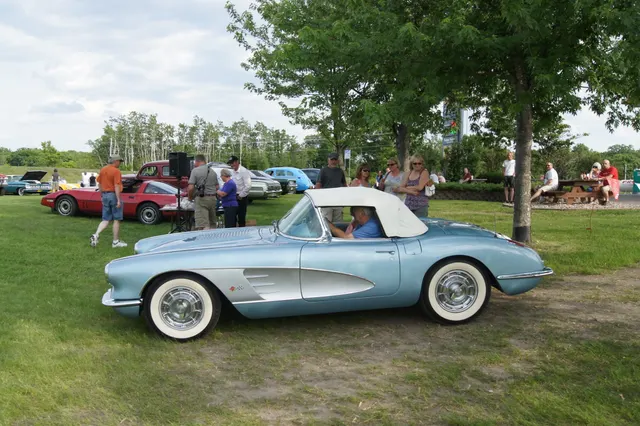 Side profile of a 1958 Corvette with auxiliary hardtop, contrasting cove, factory-style wheel covers, and whitewalls.