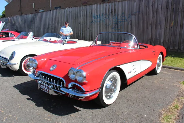 Open Signet Red roadster showing the two-seat proportions, quad-headlamp front, coves, and factory-style wheel covers.