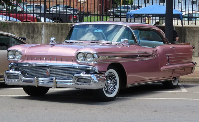 Exact-year Rose Mist Metallic Holiday sedan retained for four-door hardtop proportions, factory-style finish, chrome treatment, lamps, bumper, wheel covers, and whitewalls.