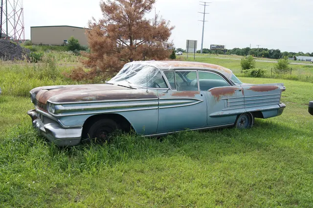 Unrestored exact-year Super 88 sedan retained for body, side molding, roof, glass, steel-wheel, and preservation context; deterioration and temporary coverings are subject-specific.