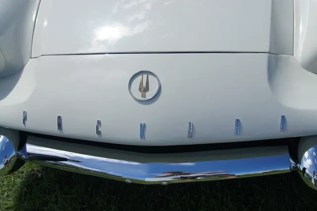 Close view of an exact-year rear fin, textured insert, Packard script, tail lamp, deck trim, and bumper for identification context.