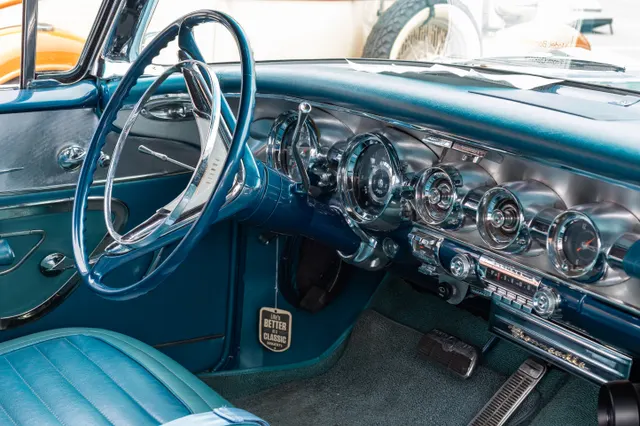 Exact-year Bonneville cabin showing the instrument panel, steering wheel, controls, door trim, pedals, and front-seat upholstery; finishes, accessories, and restoration details remain specific to the photographed car.