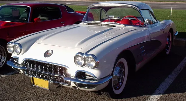 Snowcrest White 1959 Corvette with removable hardtop, silver coves, full wheel covers, and red interior.