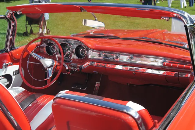 Restored 1959 Bonneville convertible cabin showing the dashboard, steering wheel, instruments, radio, controls, upholstery, and door trim; colors, materials, and accessories remain specific to the photographed car.