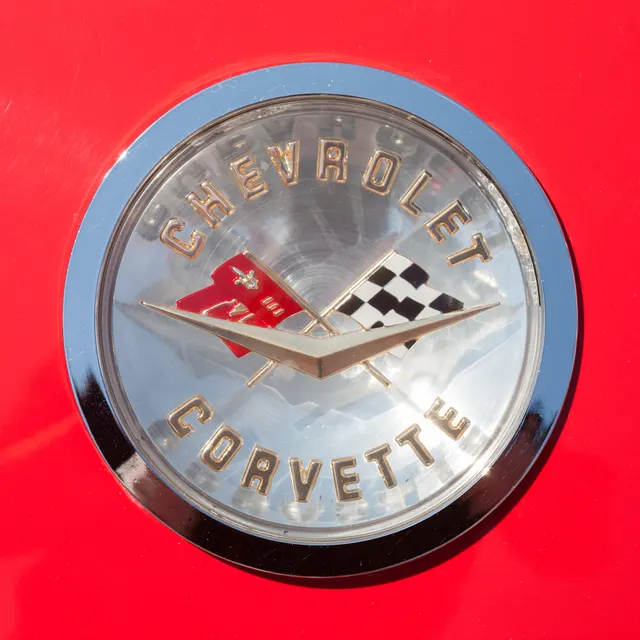 Close view of the Chevrolet Corvette emblem on a 1960 roadster deck, retained as exact-year trim and restoration context.