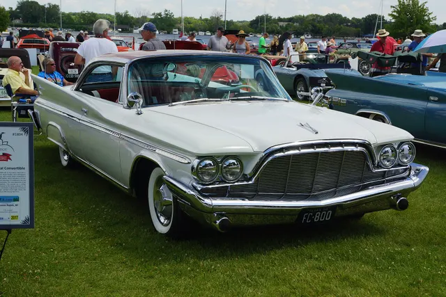 Second exact-model two-door hardtop view documenting the grille, hood, quad lamps, bumper, roof, body-side trim, fins, wheel covers, and whitewall tires.