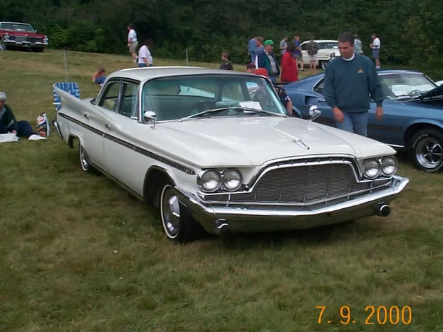 Exact-model four-door sedan front three-quarter view documenting the pillared roof, door frames, shared nose, body-side trim, fins, and factory-style wheel covers.