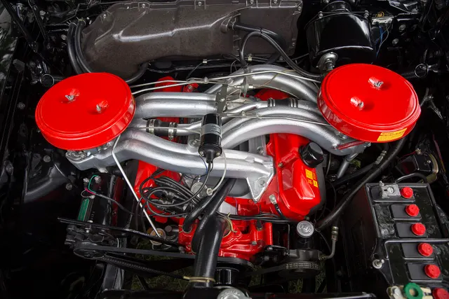 Restored 1960 Polara D-500 engine bay showing the 383-cubic-inch V8 and cross-ram induction layout; finishes, service hardware, and restoration details remain specific to the photographed car.