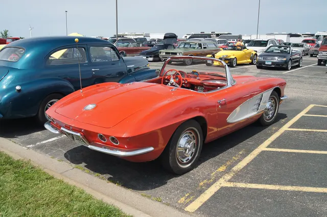 Roman Red 1961 Corvette in rear three-quarter view, showing the model year's new ducktail panel and four round taillamps.