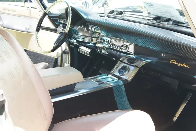 Closer cabin view showing the front buckets, full console, controls, dashboard, and upholstery; restoration finishes remain car-specific.
