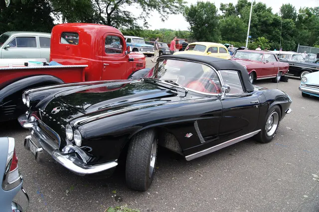 Tuxedo Black 1962 Corvette with its hood open; nonfactory wheels and show presentation are labeled restoration context.