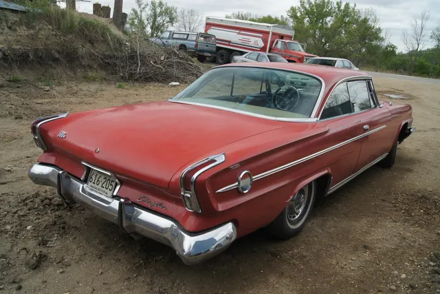 Hardtop rear three-quarter view showing the roof, deck, lamps, bumper, side medallion, body contour, and wheel-cover context.