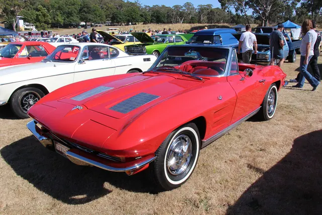 Restored red 1963 Corvette convertible showing the open two-seat body and stock-era exterior proportions.