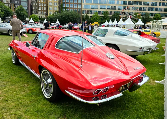 Restored red split-window coupe in rear three-quarter view, retained as body-restoration and one-year styling context.