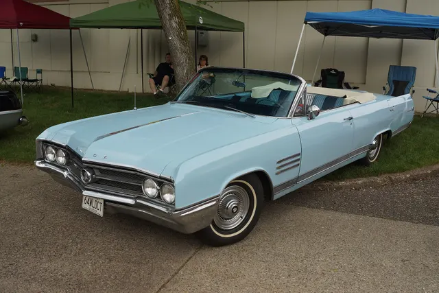 Exact-year convertible retained for the 1964 grille, headlamps, hood lettering, venti-port ornaments, lower brightwork, open body, cabin, wheel covers, and whitewalls.