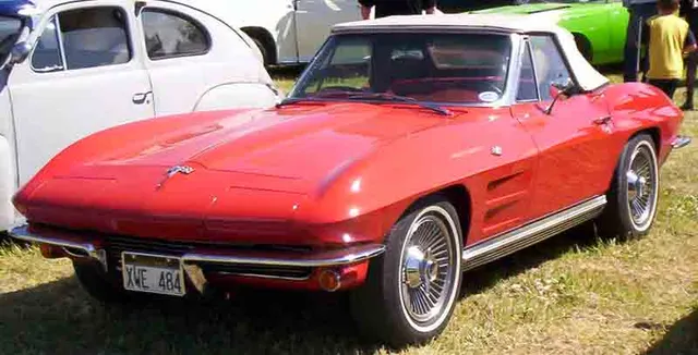 Stock-presenting red 1964 convertible in front three-quarter view with standard-style wheel covers.