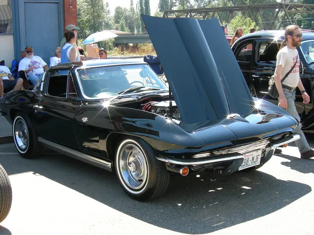 Restored black 1964 coupe with the hood open, showing the revised hood surface and front body shape.