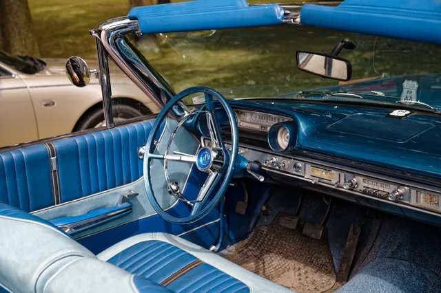 Exact-year regular Galaxie 500 convertible cabin showing the bench seat, instrument panel, steering wheel, column controls, pedals, door trim, and two-tone upholstery; condition remains specific to the photographed car.