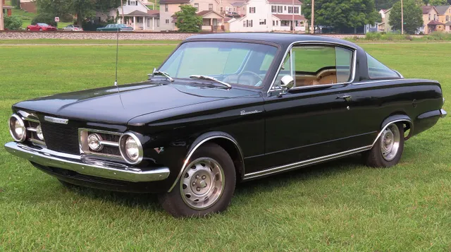 Front view of an exact-year Barracuda showing the split grille, round headlamps, inboard parking lamps, bumper, hood, and fastback roof.