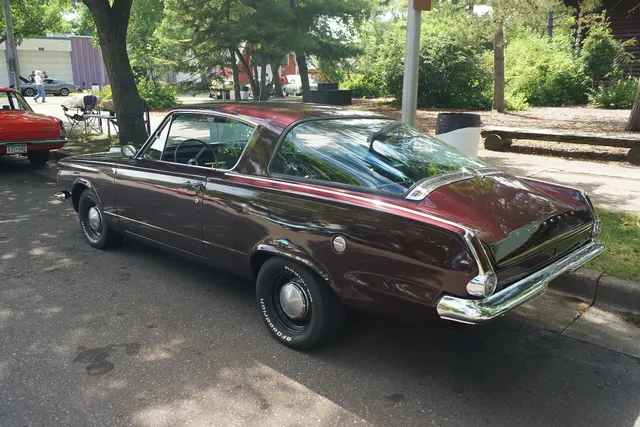 Elevated rear-side view documenting the wraparound rear window, chrome surround, deck trim, tail shape, and fastback body construction.