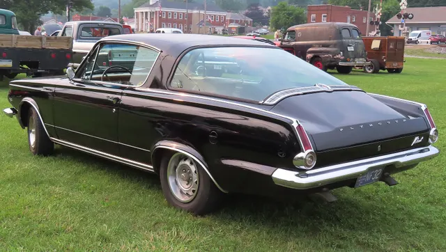 Rear three-quarter view of an exact-year Barracuda showing the wraparound glass, deck trim, tail lamps, bumper, roofline, and body-side proportions.