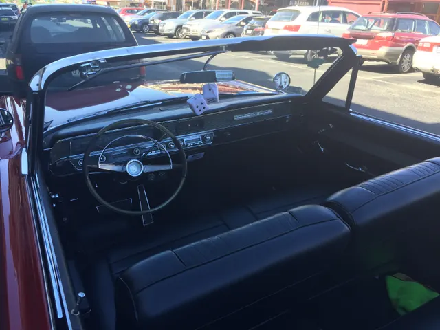 Exact-year Catalina convertible cabin showing the dashboard, steering wheel, instruments, radio, bench seats, door trim, and control layout; convertible body, upholstery, accessories, condition, and restoration details remain specific to the photographed car.