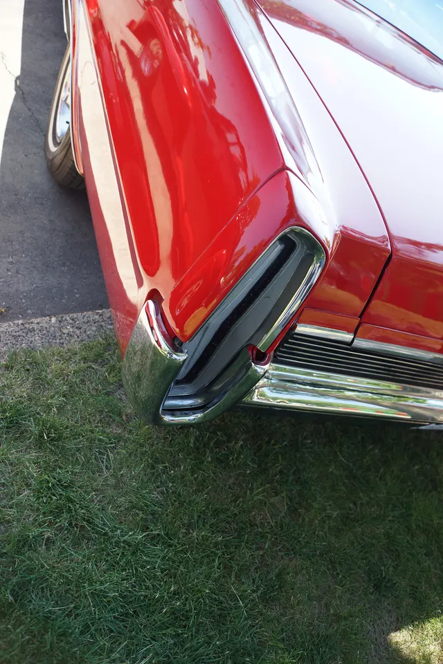Exact-year close view of the Grand Prix rear quarter, vertical tail lamp, bumper, deck edge, paint, and brightwork; restoration details remain subject-specific.