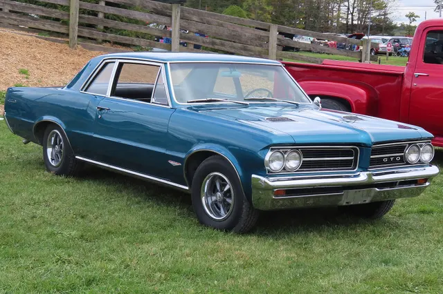 1964 Pontiac GTO Sports Coupe front-right view; used for grille, hood, wheel/tire, and stance context.