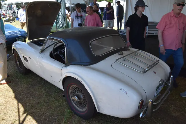 Rear three-quarter view of the same survivor 1964 Cobra showing its slab-side body, hardtop, rack, and wire wheels.