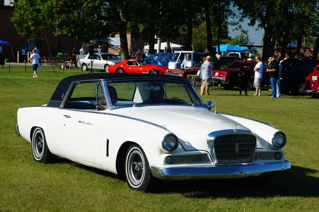 Front three-quarter view of an exact-year white Hawk with the optional black forward-half Sports Roof, final-year grille, bright trim, and body stance.