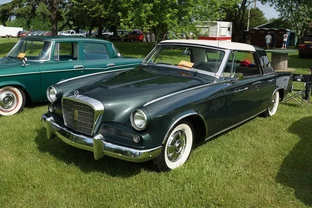 Front and side view documenting the final-year grille, contrasting Sports Roof, body trim, 15-inch wheel stance, and factory-style AC-3155 full wheel covers.