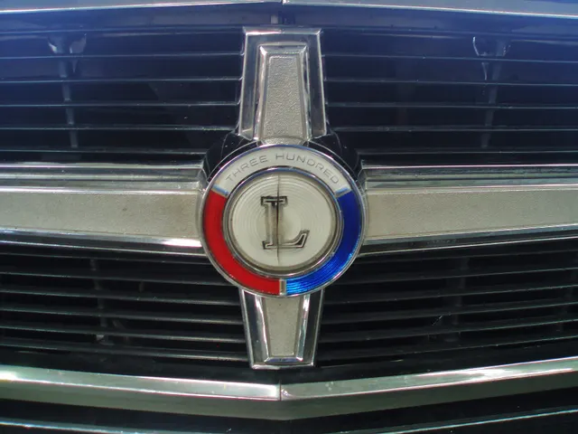 Close view of the grille crossbar and round letter medallion for identity and trim inspection context.